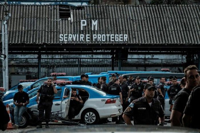 Military police officers gather as their relatives block the entrance to the police station in Rio de Janeiro on February 10, 2017