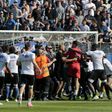 Bastia supporters invade the pitch to try to attack Lyon's Portuguese goalkeeper Anthony Lopes (in red) and others players during their warm-up prior to the French Ligue 1 match at the Armand Cesari stadium in Bastia, Corsica on April 16, 2017
