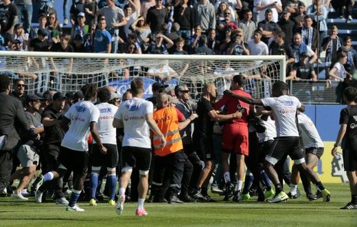 Bastia supporters invade the pitch to try to attack Lyon's Portuguese goalkeeper Anthony Lopes (in red) and others players during their warm-up prior to the French Ligue 1 match at the Armand Cesari stadium in Bastia, Corsica on April 16, 2017