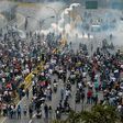 Police fired tear gas and rubber bullets to break up thousands of marchers as they reached a vital freeway in Caracas