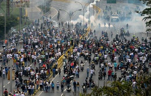 Police fired tear gas and rubber bullets to break up thousands of marchers as they reached a vital freeway in Caracas