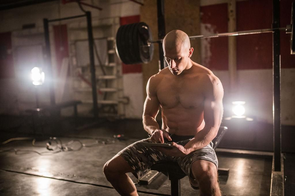 Man uses tablet in the gym