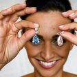 A model poses with the "The Apollo Blue" and "The Artemis Pink" diamonds, mounted as earrings, sold for a collective $57.4-million