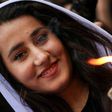 An Iraqi Yazidi woman carries a paraffin torch outside Lalish temple, the holiest shrine of her faith, on April 18, 2017, on the eve of Yazidi New Year