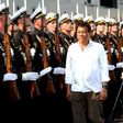 Philippine President Rodrigo Duterte (R) walks past honour guards during a visit to the Russian Guided Missile Cruiser "Varyag” docked at the Port of Manila on April 21, 2017