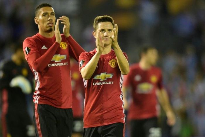 Manchester United's Chris Smalling (L) and Ander Herrera applaud fans at the end of their UEFA Europa League semi-final 1st leg match against Celta Vigo, at the Balaidos stadium in Vigo, on May 4, 2017