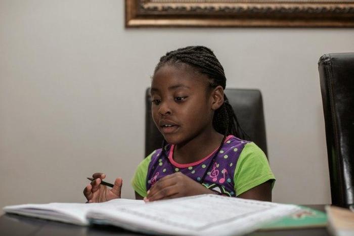 Seven-year-old author Michelle Nkamankeng does her homework at her house in Johannesburg, South Africa