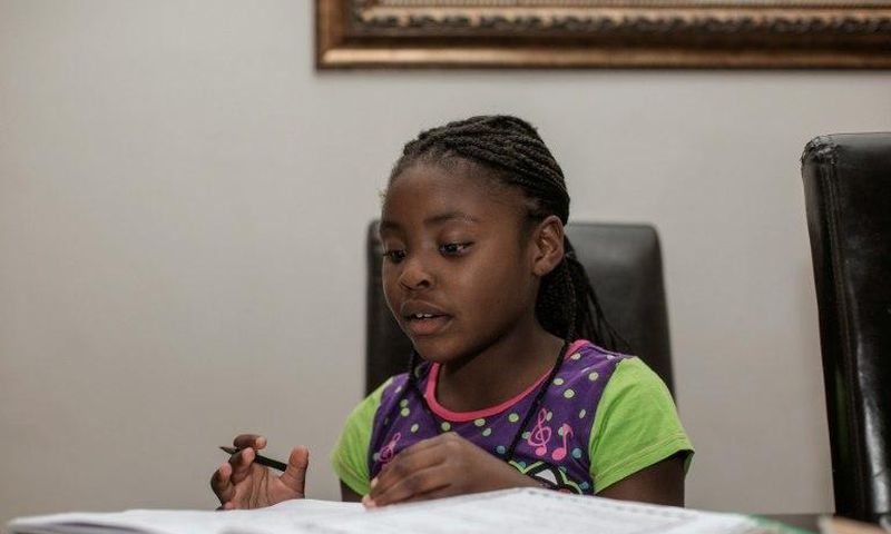 Seven-year-old author Michelle Nkamankeng does her homework at her house in Johannesburg, South Africa