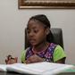Seven-year-old author Michelle Nkamankeng does her homework at her house in Johannesburg, South Africa