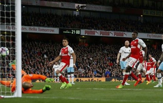 Arsenal's midfielder Mesut Ozil (2nd R) watches as his shot beats West Ham United's goalkeeper Darren Randolph (L) for the opening goal of the English Premier League football match between Arsenal and West Ham United on April 5, 2017