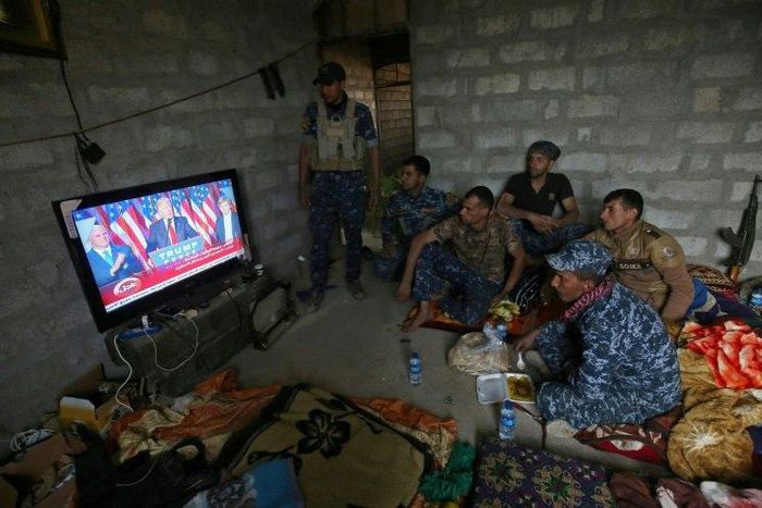 Members of the Iraqi armed forces watch Donald Trump giving a speech after he won the US presidential elections in November
