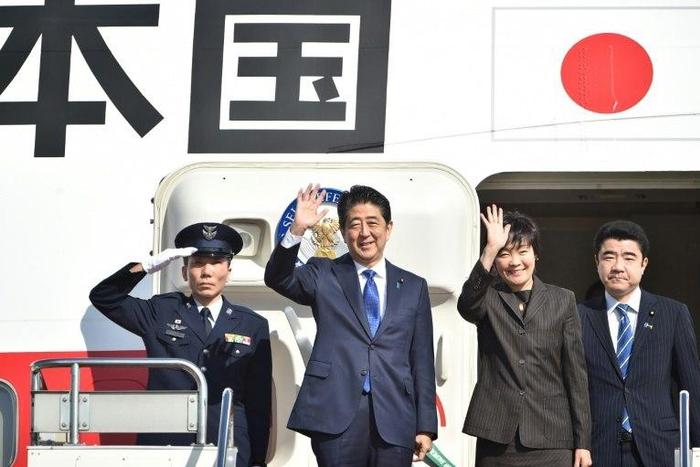 Japan's Prime Minister Shinzo Abe (2nd L) and his wife Akie wave to well-wishers prior to boarding a government plane at Tokyo's Haneda on November 17, 2016