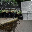 A woman kneels during a silent march by the opposition in a show of condemnation of the government of Venezuelan President Nicolas Maduro, in Caracas