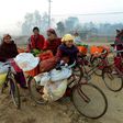 Female vendors, using their bicycles to carry their vegetables, arrive to sell their wares at a market in Nepal this February