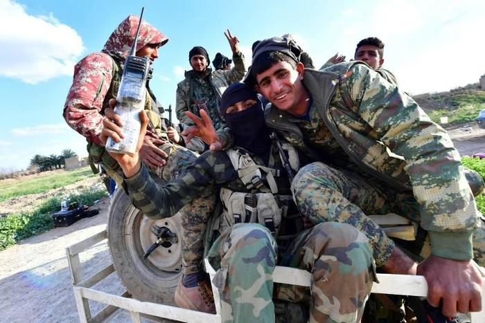 Fighters of the Kurdish-led Syrian Democratic Forces make victory signs as they return from the front after delivering a killer blow to the last vestige of the Islamic State group's caliphate