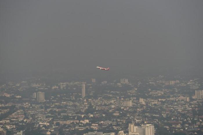 A commercial plane flies over smog-covered Chiang Mai on Tuesday