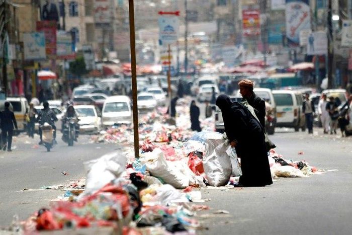 Yemenis salvage for discarded items in piles of rubbish lining a road in Sanaa on May 9, 2017