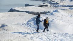 People walk along Lake Michigan's frozen shoreline as temperatures dropped to -20 degrees F (-29C) Chicago