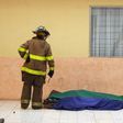A firefighter looks at two victims at a government-run children's shelter in San Jose Pinula after fire swept the building east of Guatemala City