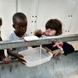 Children brush their teeth at the Souda municipality-run refugee camp on the Greek island of Chios on October 13, 2016