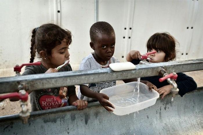 Children brush their teeth at the Souda municipality-run refugee camp on the Greek island of Chios on October 13, 2016