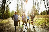 Smiling friends running together in park