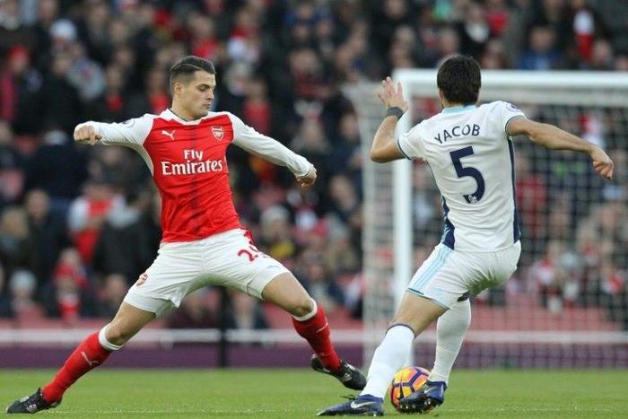Arsenal's Swiss midfielder Granit Xhaka (L) tackles West Bromwich Albion's Argentinian midfielder Claudio Yacob during the English Premier League match at the Emirates Stadium in London on December 26, 2016