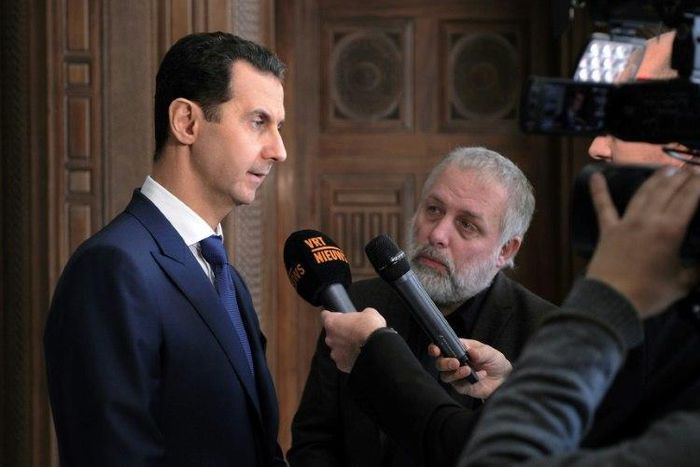Syrian President Bashar al-Assad (left) speaks to foreign reporters in Damascus, on February 7, 2017
