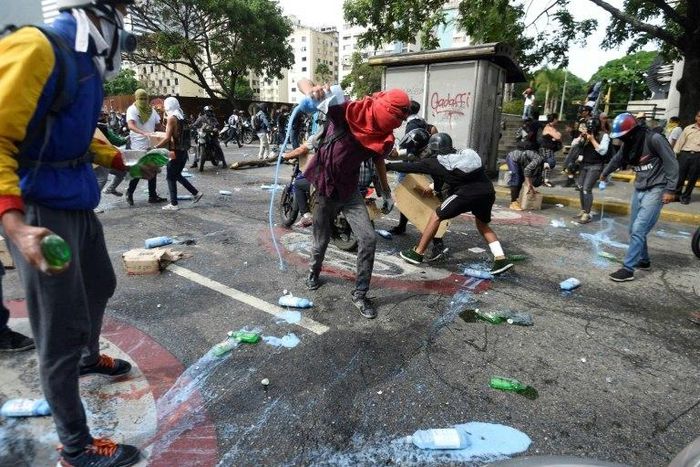 Opposition demonstrators clash with riot police in Caracas, on May 24, 2017