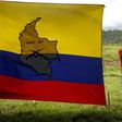A boy stands next to a FARC-EP flag in the group's birthplace in Marquetalia, center-west Colombia