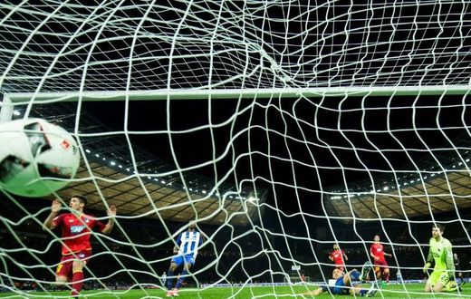 Hoffenheim's forward Andrej Kramaric (L) scores his side's 3rd goal past Hertha Berlin's goalkeeper Rune Jarstein (R) during the German First division Bundesliga football match March 31, 2017