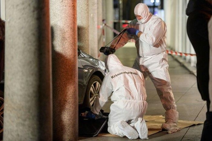 Police officers investigate the car used by a man to plough into pedestrians before he was shot by police on February 25, 2017