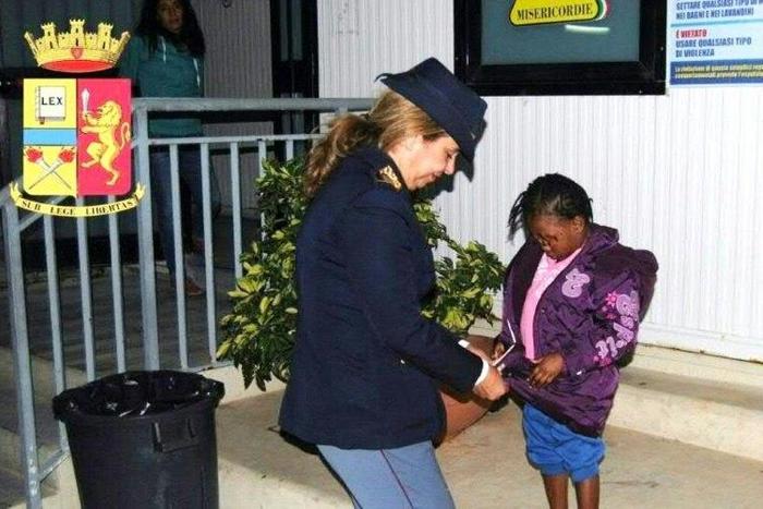 Police officer Maria Volpe takes care of Oumoh in Lampedusa on November 5