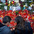 A couple lights candles at the end of a march in the memory of the 64 people who were killed one year ago when Colectiv club caught fire during a rock concert, on October 30, 2016 in Bucharest