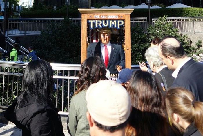 People look at the 'All-Seeing Trump', a fortune-telling fairground attraction in New York on October 12, 2016