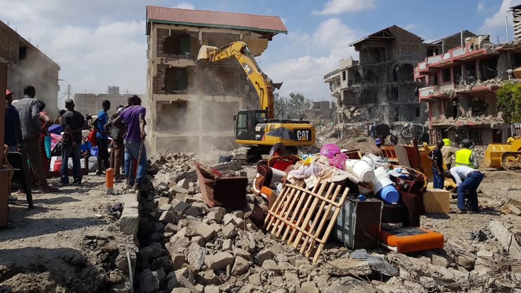 A bulldozer brings down a building Nyama Villa estate
