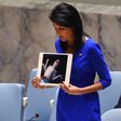 US Ambassador to the UN Nikki Haley holds photos of victims as she speaks at the UN Security Council on April 5, 2017, about the suspected deadly chemical attack that killed civilians, including children, in Syria