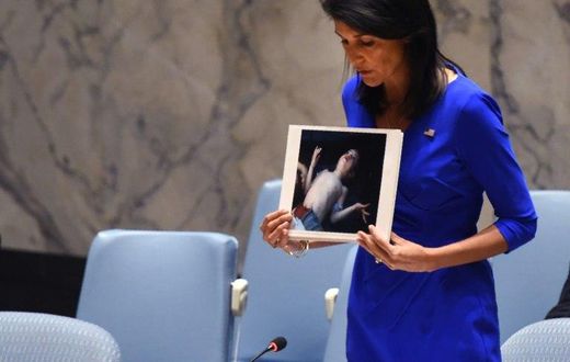 US Ambassador to the UN Nikki Haley holds photos of victims as she speaks at the UN Security Council on April 5, 2017, about the suspected deadly chemical attack that killed civilians, including children, in Syria