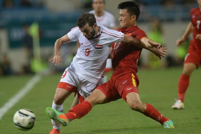 Syria's Mahmoud Al-Mawas (L) fights for the ball with Vietnam's Tran Dinh Dong during a friendly at Hanoi's My Dinh stadium on May 31, 2016