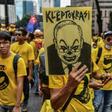 A protester holds a poster depicting Najib Razak during a mass rally in Kuala Lumpur on November 19, 2016