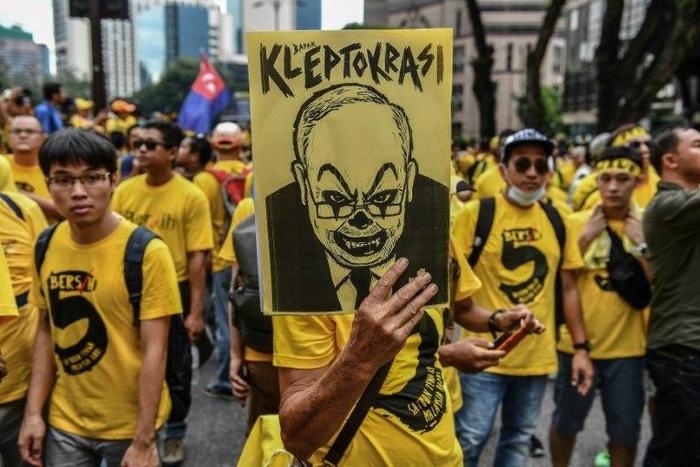 A protester holds a poster depicting Najib Razak during a mass rally in Kuala Lumpur on November 19, 2016