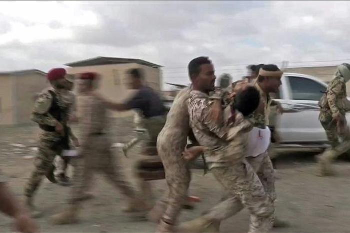 Loyalist Yemeni troops rush a wounded comrade for treatment after a rebel drone strike that killed six and wounded 12, including top brass