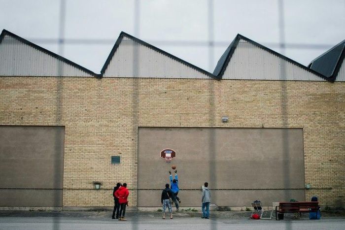 Refugees play basketball outside the Sundbyberg shelter, north-west of Stockholm, on October 13, 2015