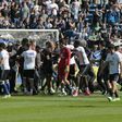 Stewards and Lyon staff members try to stop Bastia's supporters who invade the pitch to fight with Lyon players during warm up prior to the French L1 Football match between Bastia and Lyon on April 16, 2017, at the Armand Cesari stadium