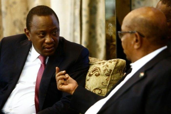 Kenyan President Uhuru Kenyatta (L) speaks with his Sudanese counterpart Omar al-Bashir during their meeting in Khartoum on October 29, 2016