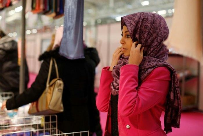 A visitor trying on a headscarf Annual Meeting of France's Muslims in 2015 north of Paris