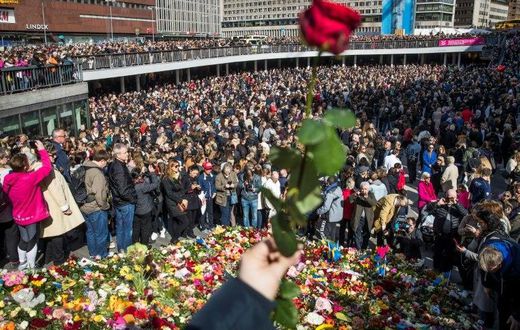 People attend a memorial ceremony on April 9, 2017 at Sergels Torg plaza in Stockholm, close to the point where a truck drove into a department store two days before