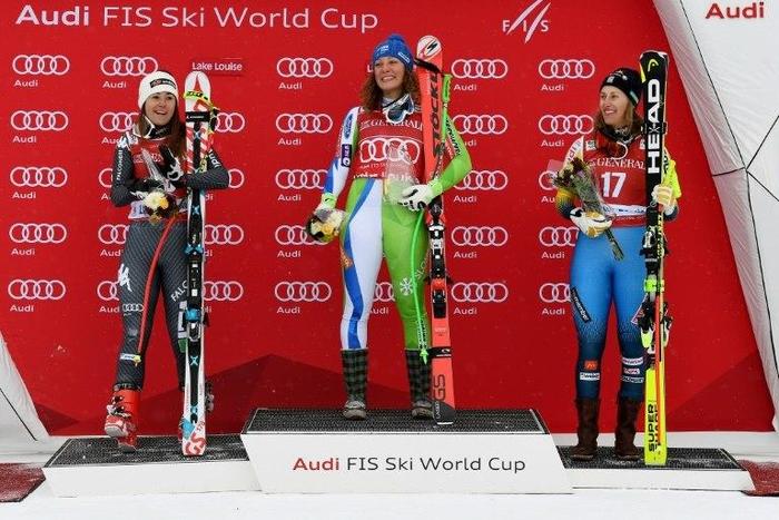 Ilka Stuhec of Slovenia (C) celebrates after winning the Audi FIS Ski World Cup 1st Women's Downhill race with second place Sofia Goggia of Italy (L) and third place Kajsa Kling of Sweden (R) in Alberta, Canada on December 2, 2016