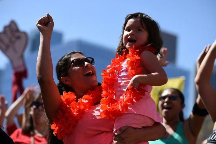 A mother and daughter cheer at the "A Day Without a Woman" rally honoring International Women's Day, in Los Angeles, California