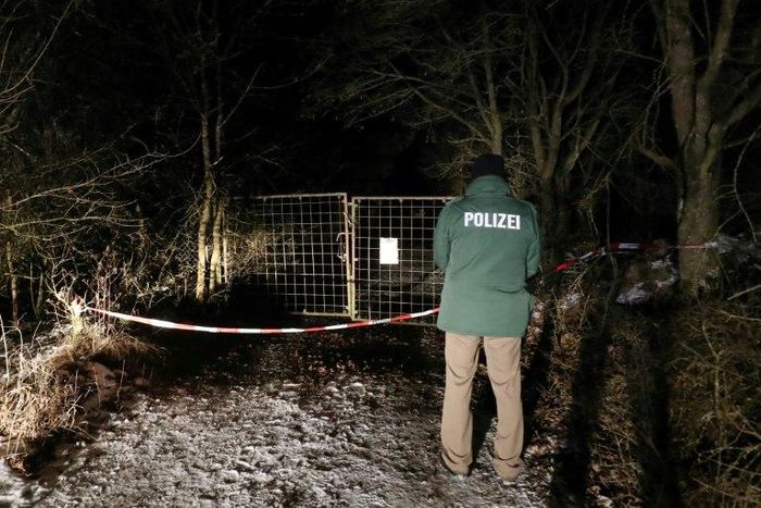 A policeman stands in front of an entrance leading to the site where six teenagers were found dead after holding a party in a garden near Arnstein, southern Germany, on January 29, 2017